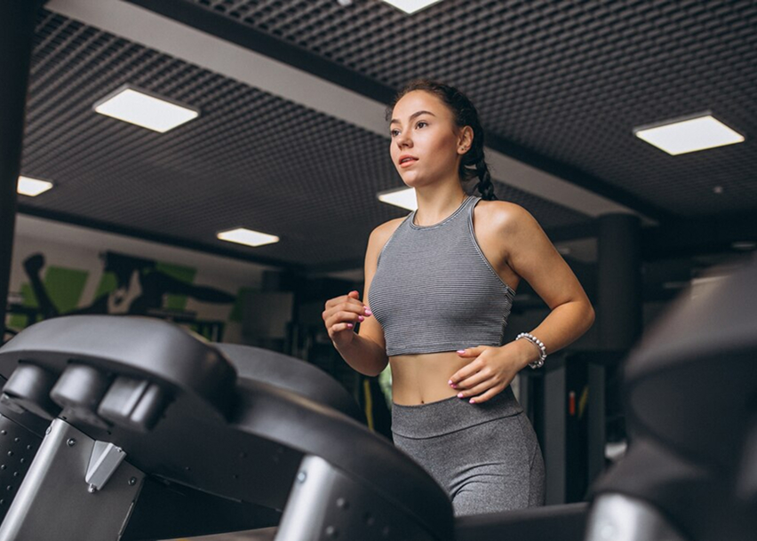 Девушка бежит на велодорожке и смотрит в перед